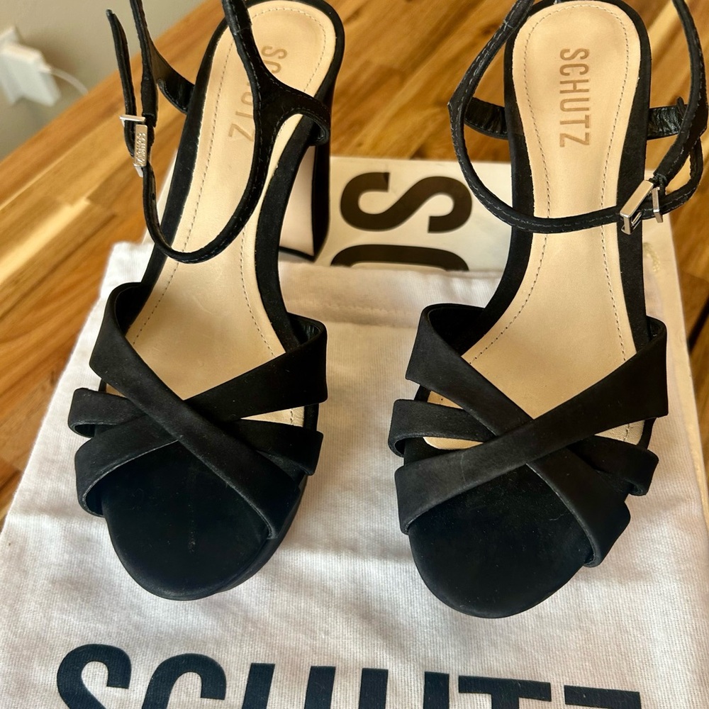 Schutz black platform heels with delicate straps and ankle buckle.